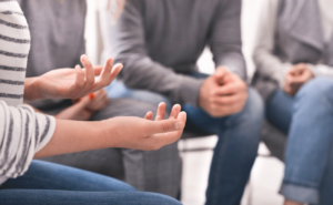 A group of people talk in a support group