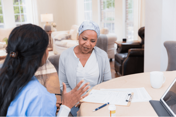 A woman in a headscarf meets with someone about her illness