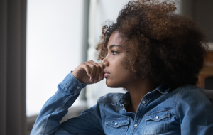 A teenager pensively looking out the window.