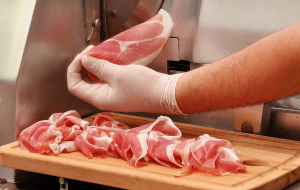 A worker slices deli meat