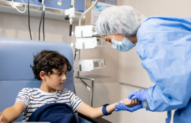 A nurse prepares a child for chemotherapy