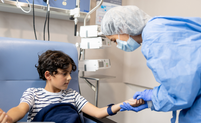 A nurse prepares a child for chemotherapy